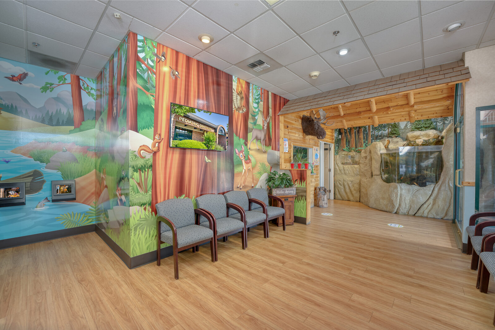 Lobby with video game booths and a forest mural