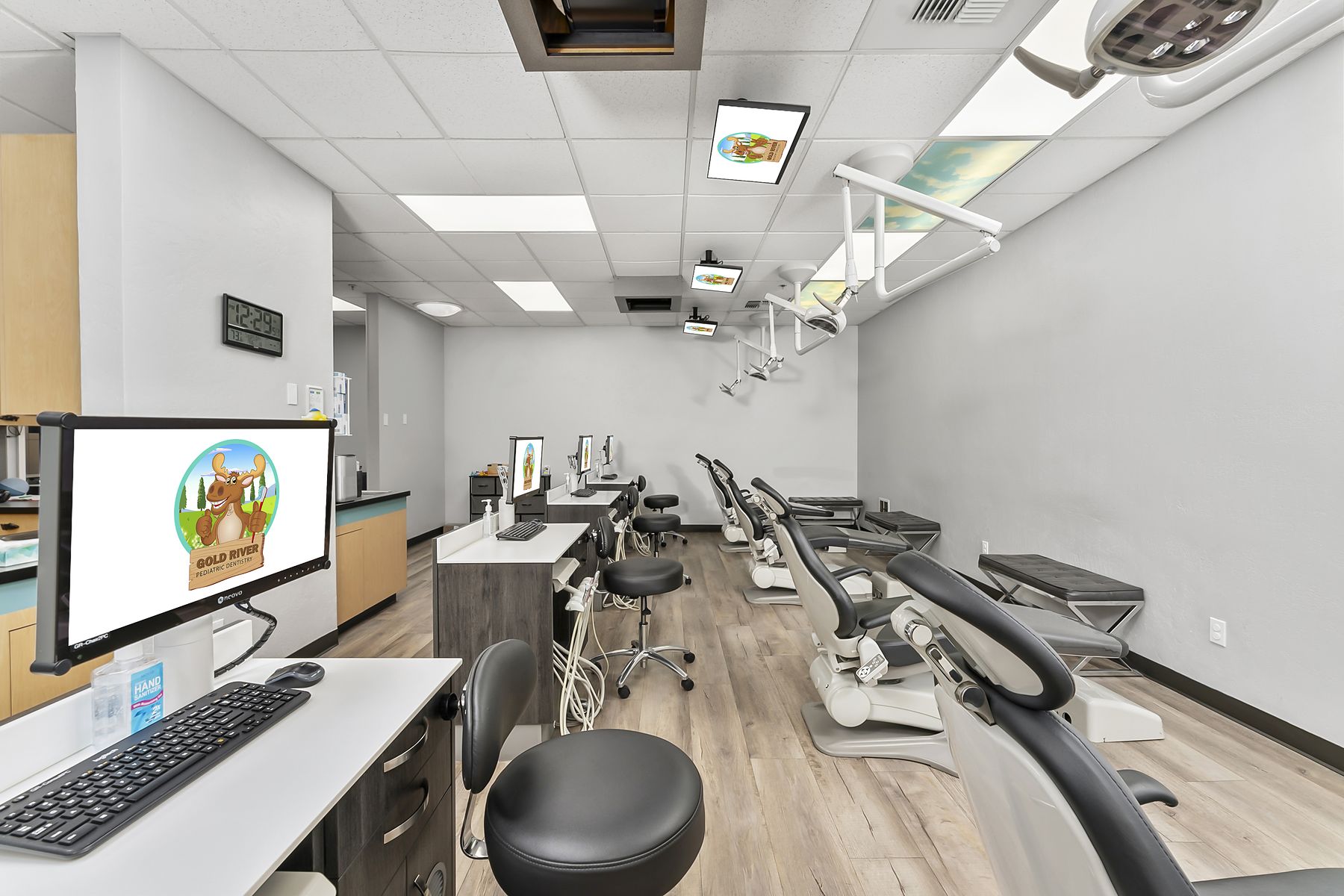 Hygiene bay with chairs, stools, and chairside monitors ready for cleanings