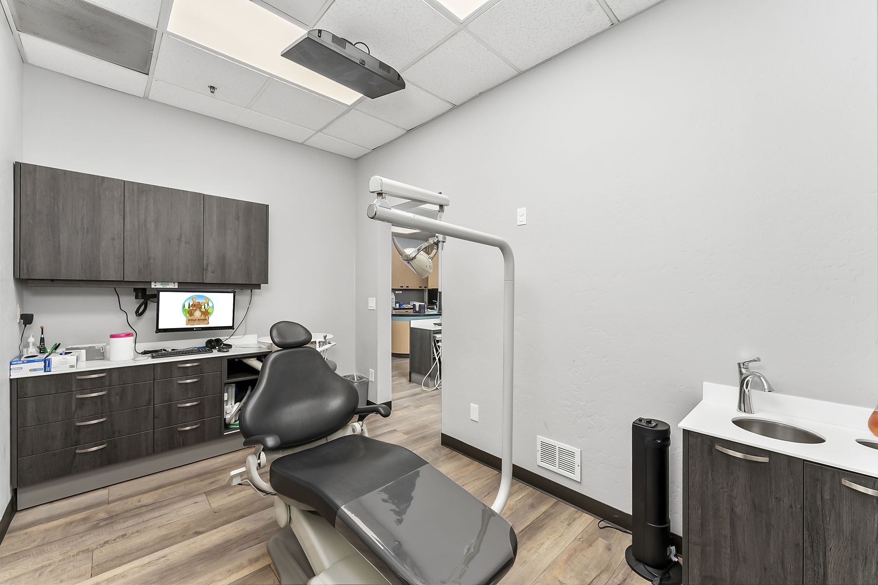 Private treatment room with a single chair and a chairside monitor